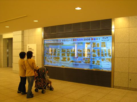 'A family looking at a wall-sized map of the cows'